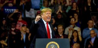 Strong Jobs Report Creates a BIG Problem for Trump Donald Trump speaking at a rally behind a presidential podium
