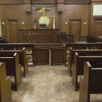 State Takes Catholic Teen to ‘Transition’ Her Interior view of an empty courtroom with wooden benches and a judges bench