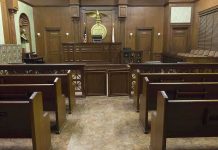 State Takes Catholic Teen to ‘Transition’ Her Interior view of an empty courtroom with wooden benches and a judges bench