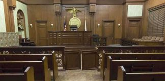 State Takes Catholic Teen to ‘Transition’ Her Interior view of an empty courtroom with wooden benches and a judges bench