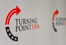 $2 Million Ultimatum Allegedly Hit TPUSA Turning Point USA logo on a backdrop