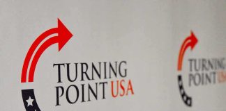 $2 Million Ultimatum Allegedly Hit TPUSA Turning Point USA logo on a backdrop