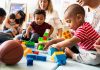 Senator Torches Trump Vaccine Flip Karyn Polito with toddlers building blocks on a play mat