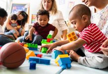 Senator Torches Trump Vaccine Flip Karyn Polito with toddlers building blocks on a play mat