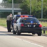 ICE Shooting Sparks Houston Uproar Police officer conducting a traffic stop on a highway