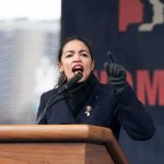 Sexts, Reddit, Nazi Ink—Dems Are All-In Woman speaking passionately at a podium outdoors