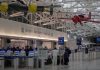 airport security checkpoint with passengers and hanging vintage airplanes