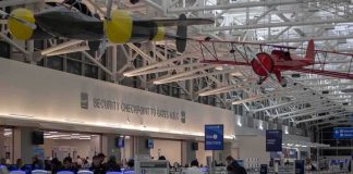 Duct-Taped Airline Passenger FIRED After Viral Meltdown airport security checkpoint with passengers and hanging vintage airplanes