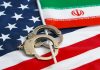 See Inside Iran’s 300% Inflation Handcuffs on U.S. flag beside Iranian flag