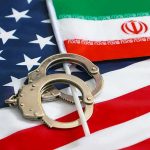 See Inside Iran’s 300% Inflation Handcuffs on U.S. flag beside Iranian flag
