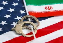 Handcuffs on U.S. flag beside Iranian flag