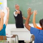 State Will Teach Students That Radical Islam Motivated 9/11 Students raising hands in a classroom while teacher points