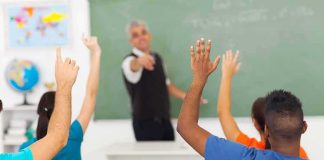 State Will Teach Students That Radical Islam Motivated 9/11 Students raising hands in a classroom while teacher points