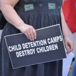 Ms. Rachel Meets Riot Shields person holding protest sign at a rally