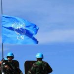 Hezbollah Veto Shreds Peace Deal UN flag above peacekeepers in blue helmets