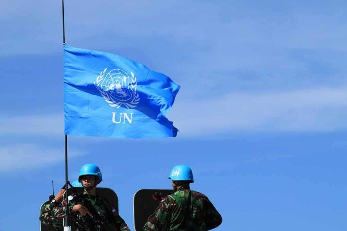 shutterstock_1480711055 UN flag above peacekeepers in blue helmets
