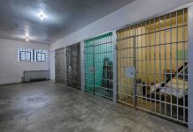 ICE Expansions: Bed Crunch Chokes Deportations Interior view of a prison cell block with metal bars and concrete flooring