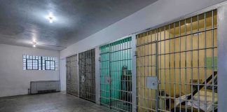 ICE Expansions: Bed Crunch Chokes Deportations Interior view of a prison cell block with metal bars and concrete flooring