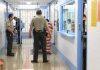 Federal Jail MELTDOWN Triggers Mass Exodus Corrections officers escort an inmate in a jail hallway