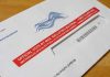 Courts Freeze USPS’s New Ballot Gate Mail-in ballot envelope with red label on wooden table
