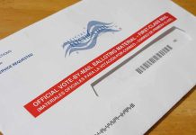 Courts Freeze USPS’s New Ballot Gate Mail-in ballot envelope with red label on wooden table
