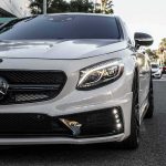 White luxury coupe front on city street