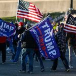 Trump Turns ‘Soft Republican’ Into Political Slur Crowd of people carrying political and American flags at a street gathering