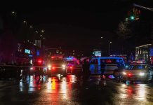 3 Dead, 6 Injured After Minneapolis Shooting Nighttime police scene with flashing lights on a wet city street