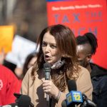 Jail The Billionaires? Senate Bid Explodes Woman speaking into a microphone at a rally