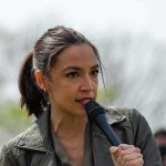 See AOC’s ‘Shifting Accent’ At Memphis Church AOC speaking into a handheld microphone outdoors