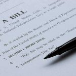 Trump and Musk FORCE Critical Vote Through Bill document with pen on paper