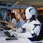 How AI Is Turning Unemployment Into a Major CRISIS Robot and office workers at computers in a modern workspace