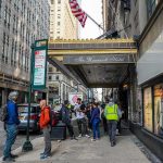 Homemade Firebomb Rattles Federal Nerve Center Andreas Hestler and pedestrians outside The Roosevelt Hotel entrance on a city sidewalk