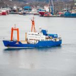 Arctic Showdown: Norway Grabs Russian Ship Blue research vessel in harbor with orange cranes