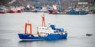 Arctic Showdown: Norway Grabs Russian Ship Blue research vessel in harbor with orange cranes