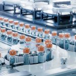 Big Tariffs, Bigger Bill — Who Pays? Pharmaceutical vials on an automated production line