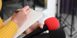 Iran Threatens South Korean If It Joins Hormuz Mission Journalist holding two microphones while writing in a notebook