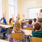 T-Shirt Battle Rewrites Classroom Free Speech Students raise hands in a classroom while a teacher stands at the front