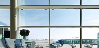 Airport terminal with plane at gate viewed through large windows