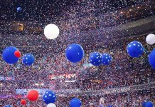 Republicans Open First-Ever Midterm Convention in Dallas Blue and white balloons with confetti falling over a crowded indoor arena