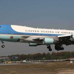 Airplane with blue and white livery landing approach