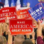 N-Word Bomb Dropped By Former GOP Advisor Crowd holding red and blue campaign signs at a political rally