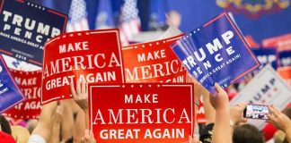 N-Word Bomb Dropped By Former GOP Advisor Crowd holding red and blue campaign signs at a political rally