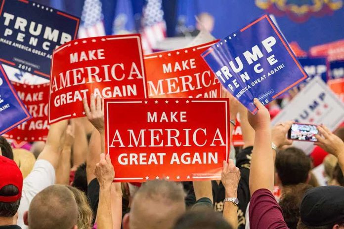 shutterstock_530768257-1 Crowd holding red and blue campaign signs at a political rally