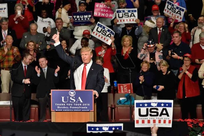 shutterstock_538492747 Donald Trump addresses a rally crowd at a podium, raising his fist