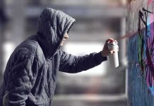 Macklemore Painted in Gaza After Tour Removal Person in hoodie spray painting a wall