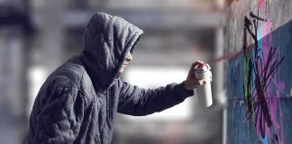 Macklemore Painted in Gaza After Tour Removal Person in hoodie spray painting a wall