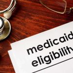 Massive Medicaid Heist: $90M Fraud Busted! Medicaid eligibility form with stethoscope and pen on desk