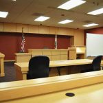 CBS Host Just Got Blindsided by the Clancy Jury Holdout Man Interior view of an empty courtroom with wooden furniture and American flags