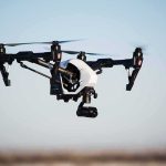 Quadcopter drone with camera flying outdoors